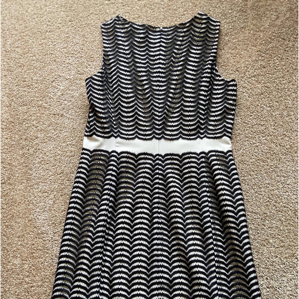 Just above the knee length sleeveless dress. Black lace over off white poly